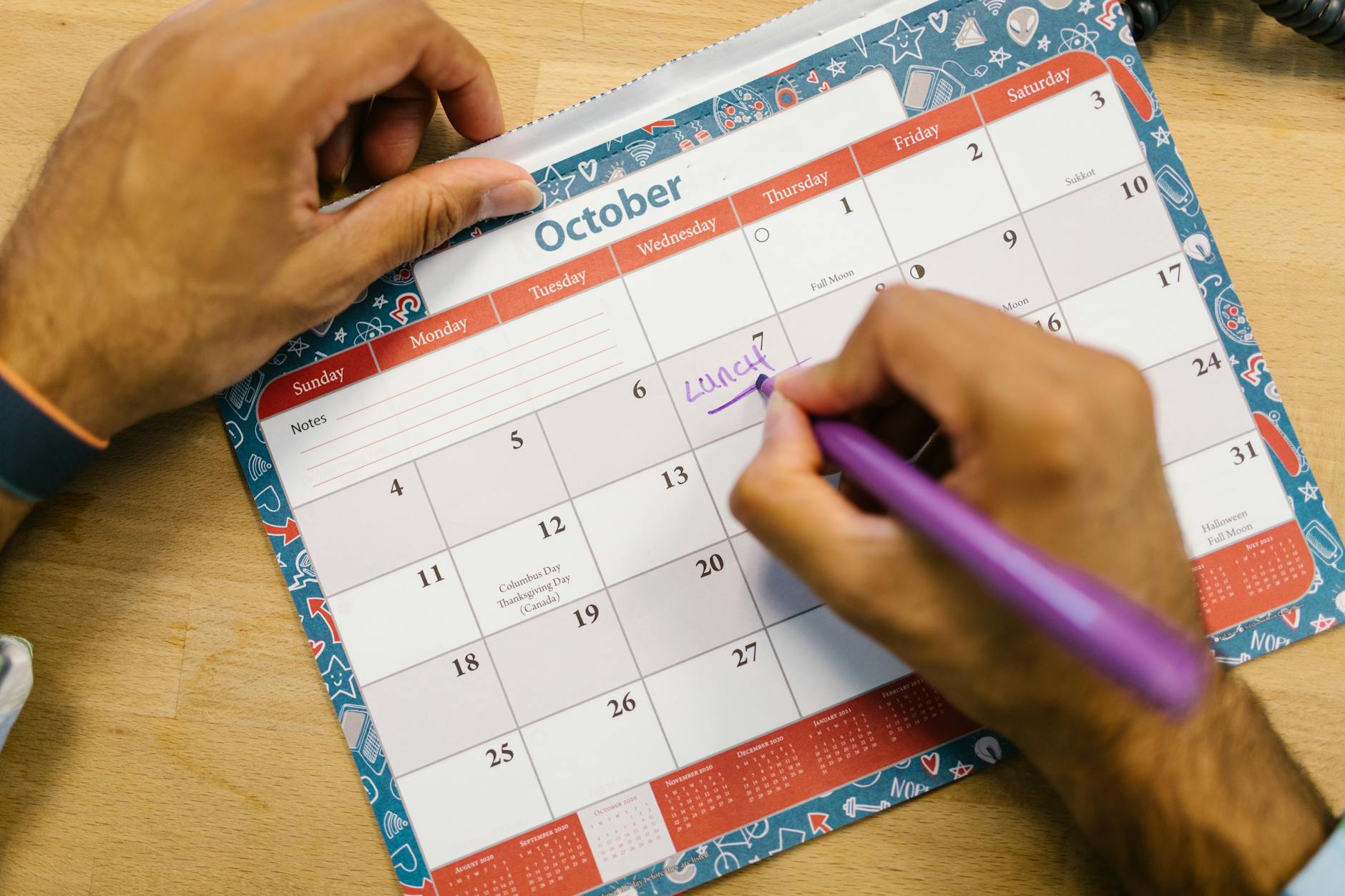 Hunter's planning desk with a calendar marked with hunting seasons, a map, and tag applications spread out